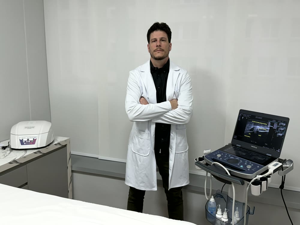 Dr. Rúbio Arruda no consultório, ao lado do ultrassom e da centrífuga